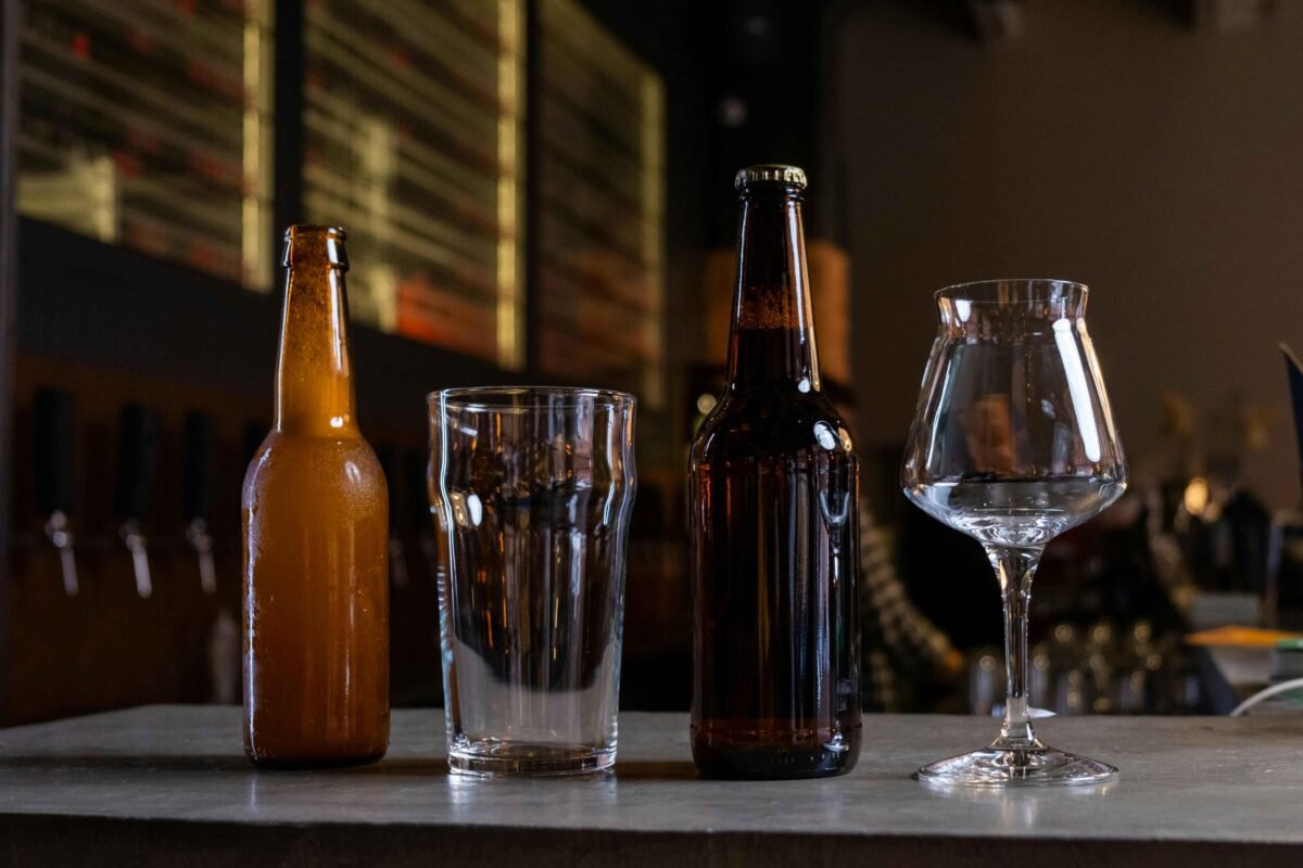 Photo of unbranded beer bottles on a table with two glasses